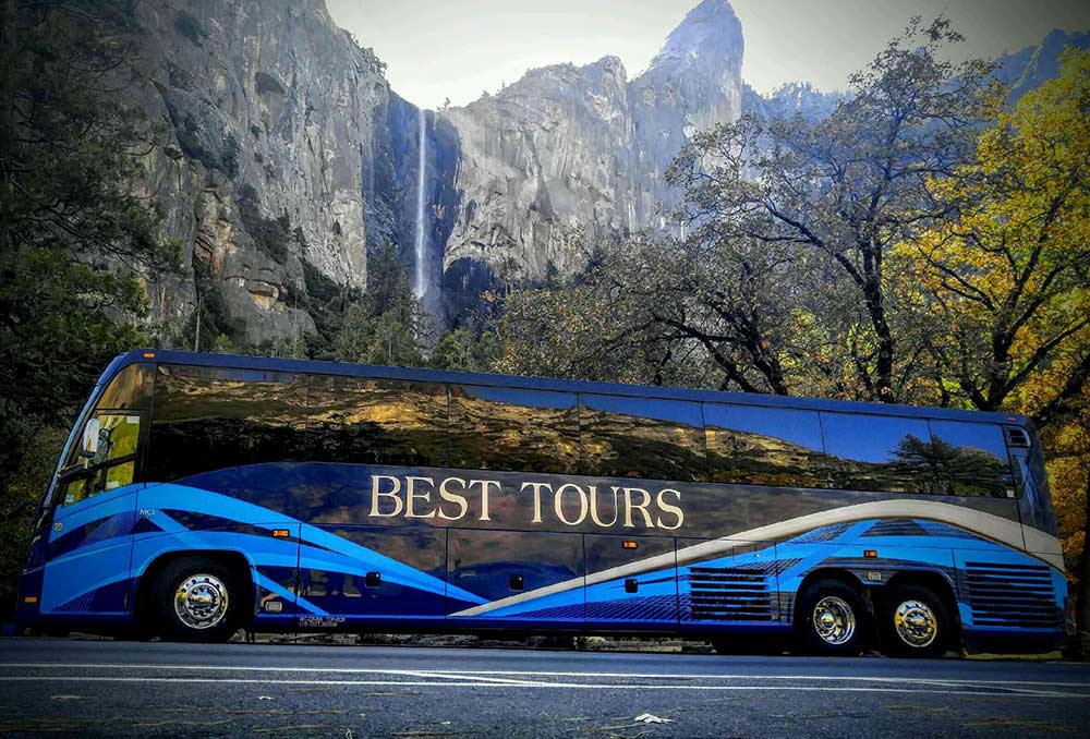 Best Tours bus parked in front of scenic waterfall
